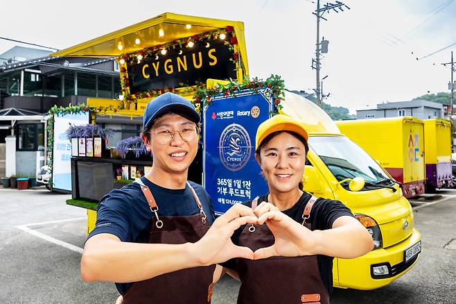 박종기(왼쪽) 시그너스커피 대표와 아내 이주현 부대표가 기부 푸드트럭 1호 앞에서 손을 모아 하트를 만들었다. 박 대표는 일하는 이유에 대해 “부모나 화려한 배경이 없어도, 다문화 가정 출신이어도 성공할 수 있음을 보여주고 싶다”고 말했다. /양수열 영상미디어 기자