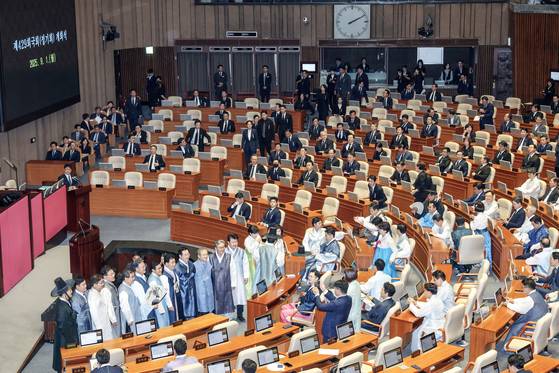 제429회 정기국회 개회식이 열린 1일 오후 한복을 입은 더불어민주당 등 일부 야당의원들이 기념사진을 찍고 있다. 검은 양복에 '근조 의회 민주주의' 리본을 단 국민의힘 의원들이 이 모습을 지켜보고 있다. 김성룡 기자