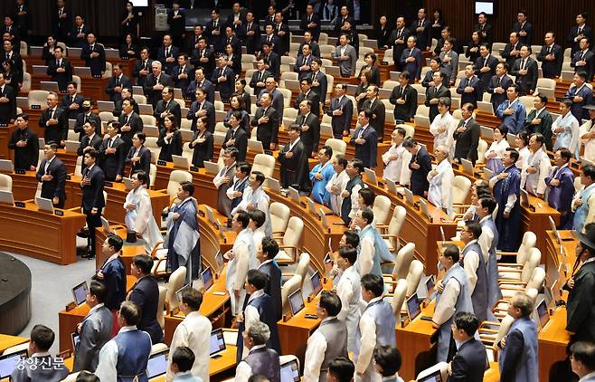 잔칫집 옆 초상집? 이재명 정부 첫 정기국회 개회식이 열린 1일 본회의장에서 한복을 차려입은 더불어민주당 의원들과 검은색 상복을 입은 국민의힘 의원들이 국민의례를 하고 있다. 박민규 선임기자