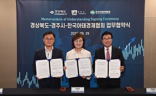 From left: Gyeongju Deputy Mayor Song Ho-jun, North Gyeongsang Province Vice Gov. for Economic Affairs Yang Geum-hee and Korea Asia-Pacific Economic Association Chair Ji Young-mo hold signed memoranda of understanding during a photo session at the signing ceremony in Seoul on Friday.