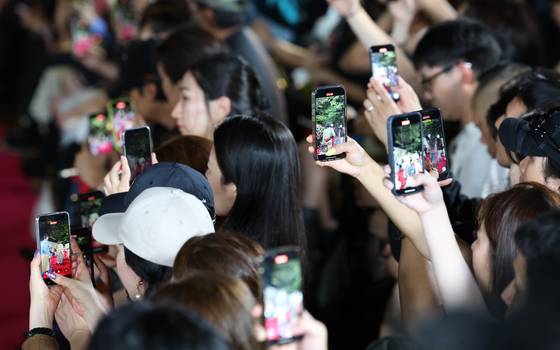 Spectators photograph models walking the stonewall path of Deoksu Palace in central Seoul during Andersson Bell’s show, which opened the 2026 Spring/Summer Seoul Fashion Week on Monday. [NEWS1]