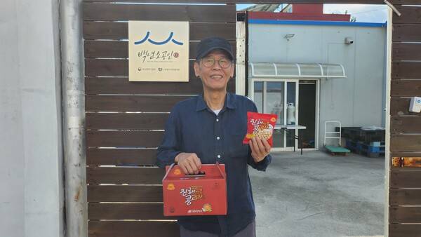 이정제 대표가 경화당 앞에서 진해 콩과자를 들고 있다. /이원재 기자