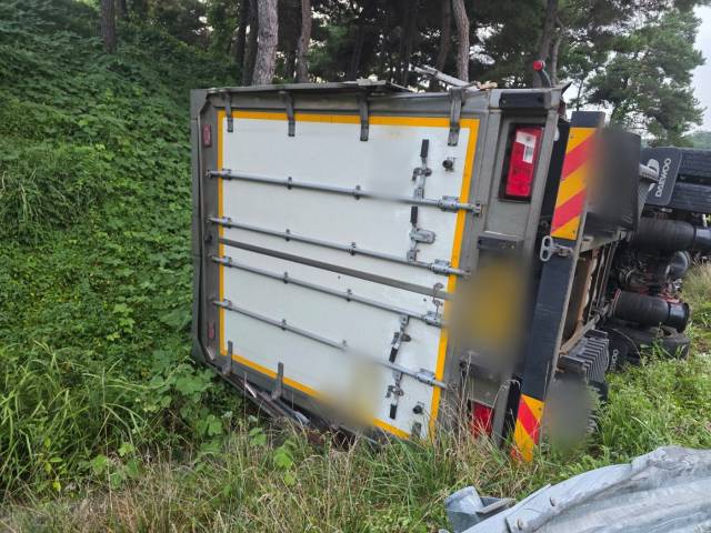 2일 오전 5시 55분께 부산 기장군 부산울산고속도로 장안IC 램프 구간에서 화물차량이 중앙 연석과 가드레일을 잇달아 들이받은 뒤 넘어졌다. 부산경찰청 고속도로순찰대 제공