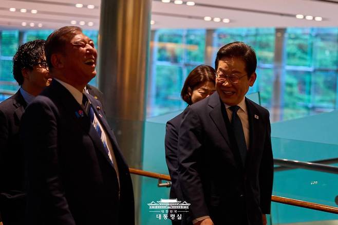 이재명 대통령과 이시바 시게루 일본 총리가 23일 일본 도쿄에서 열린 정상회담에 앞서 함께 웃으며 이동하고 있다. 대통령실 홈페이지