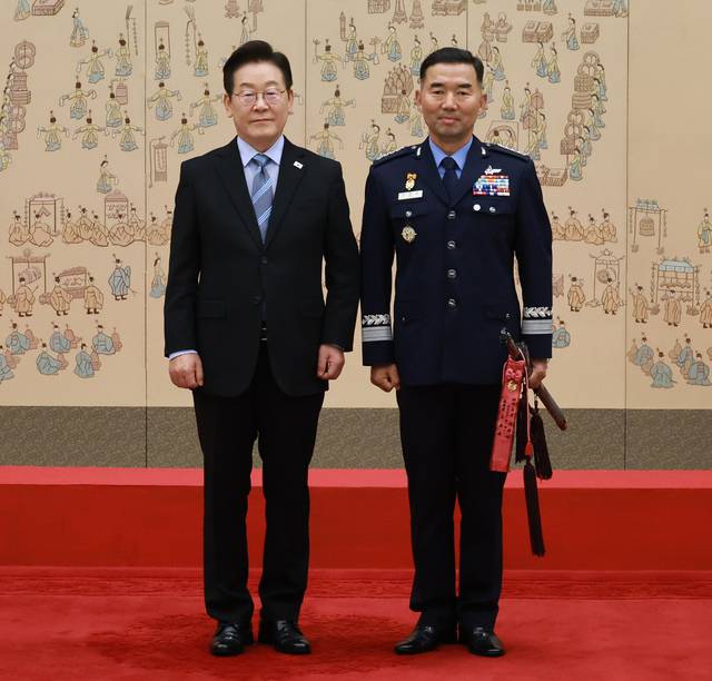 이재명 대통령이 2일 서울 용산 대통령실 청사에서 열린 대장 진급·보직 신고식에서 합동참모의장 후보자인 진영승 공군 전략사령관에게 삼정검에 수치 수여 후 기념촬영을 하고 있다. 연합뉴스