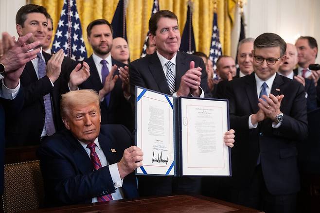 도널드 트럼프 대통령이 지난 7월18일 금요일, 워싱턴 백악관 이스트룸에서 디지털 화폐를 규율하는 첫 번째 주요 법률인  ‘지니어스 법안’에 서명하고 있다. 연합뉴스