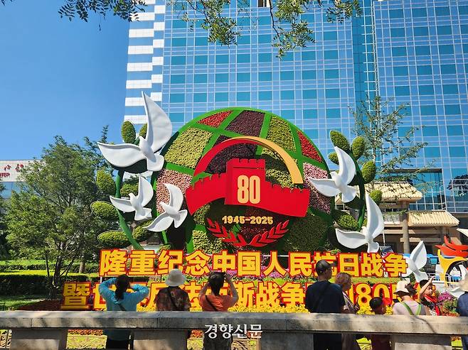 중국 항일전쟁 및 2차 세계대전 승리 80주넌 기념행사를 이틀 앞둔 1일 시민들이 베이징 창안제에 설치된 기념화단을 찍고 있다.