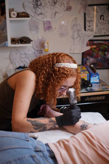 Sun Child gives a tattoo to her client in the United States in April last year. [SUN CHILD]