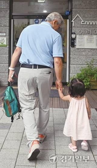 김정백씨가 손녀 황시엘양의 손을 잡고 유치원에 데려다주고 있다. 조주현기자