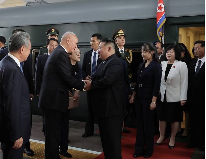 김정은 북한 국무위원장이 2일 전용열차편으로 중국 베이징역에 도착해 영접나온 중국측 인사들과 악수하고 있다. 김 위원장 뒤편으로 이번 순방에 깜짝 동행한 김 위원장의 딸 김주애도 보인다. 조선중앙TV·연합뉴스