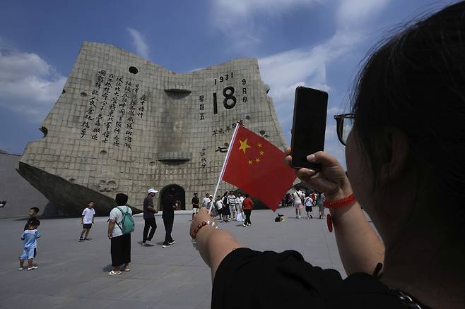 중국인들이 지난달 12일(현지시간) 전승절 기념물 앞에서 기념촬영을 하고 있다. [AP]