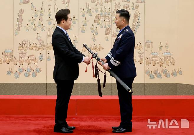 [서울=뉴시스] 최동준 기자 = 이재명 대통령이 2일 서울 용산 대통령실 청사에서 열린 대장 진급·보직 신고 및 삼정검 수치 수여식에서 합동참모의장 후보자인 진영승 전략사령관의 삼정검에 수치를 달아주고 있다. (대통령실통신사진기자단) 2025.09.02. photocdj@newsis.com