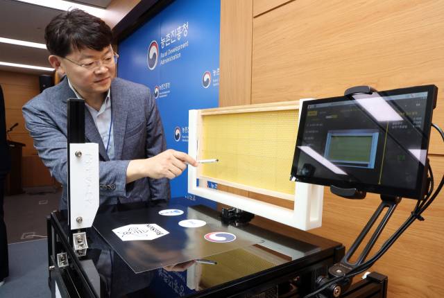 지난달 20일 정부세종청사 농식품부 기자실에서 반복되는 겨울철 꿀벌 집단 폐사의 주요 원인으로 지목된 '꿀벌응애'를 빠르고 정확하게 진단할 수 있는 세계 최초의 인공지능 기반 '꿀벌응애 실시간 검출장치(BeeSion)'를 강원대학교와 공동 개발했다고 밝혔다. 사진은 강원대 연구팀 모창연 교수가 장치를 설명하는 모습. 연합뉴스.