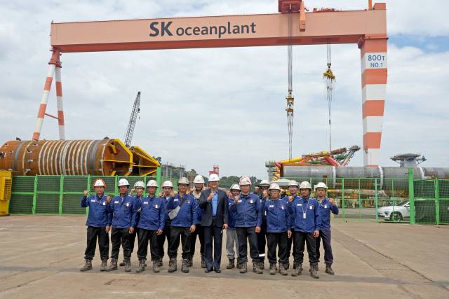 SK오션플랜트 본사를 방문한 태국 해군 참모총장 등 방문단이 현장에서 근무 중인 태국인 용접사와 함께 기념 촬영을 하고 있다. 사진 제공=SK오션플랜트