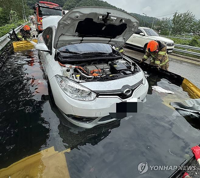 지난달 7일 오전 8시54분께 충북 괴산군 문광면 문법리 유평터널 인근에서 전기차 화재가 발생해 소방당국이 이동형 수조를 활용해 진화 작업을 펴고 있다. [괴산소방서 제공. 재판매 및 DB 금지]