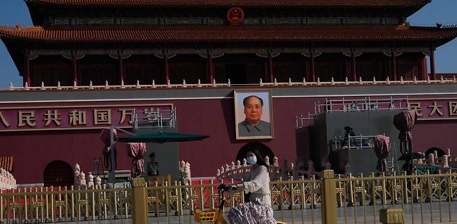 지난달 31일 중국 베이징 시민이 자전거를 타고 3일 전승절 80주년 열병식이 열릴 톈안먼 광장을 지나고 있다. 김정은 북한 국무위원장, 시진핑 중국 국가주석, 블라디미르 푸틴 러시아 대통령은 이번 열병식에서 나란히 앉기로 했다. 세 정상이 연쇄 양자 정상회담을 가질 가능성도 제기된다. 베이징=AP 뉴시스