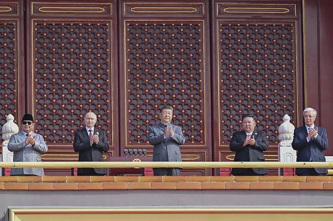 시진핑 중국 국가주석이 3일(현지 시간) 베이징 톈안먼 성루(망루)에서 김정은(오른쪽) 북한 국무위원장, 블라디미르 푸틴 러시아 대통령 등과 함께 자리해 광장에서 열린 ‘중국 인민 항일 전쟁 및 세계 반파시스트 전쟁 승리(전승절)’ 80주년 기념 열병식을 보며 박수하고 있다. 2025.09.03. [베이징=신화/뉴시스]
