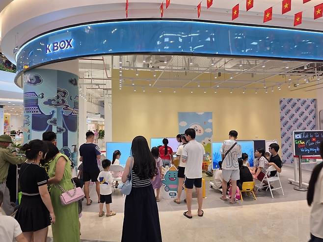 베트남 하노이 빈컴 메가몰 오션시티의 케이박스(K-Box) 매장에서 현지 가족들이 엘포박스의 스마트러닝 기기 '톡톡박스'를 체험하고 있다.