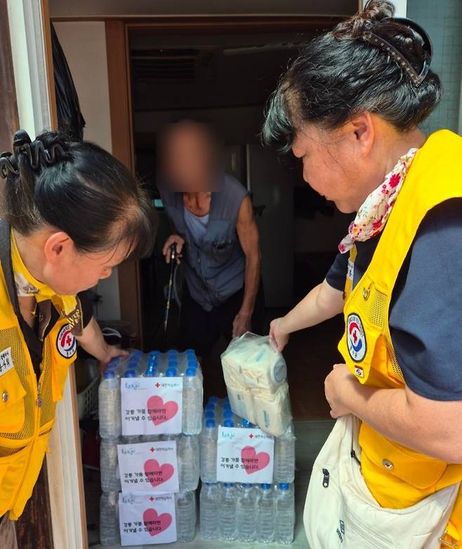 대한적십자사 강원특별자치도지사 봉사원들이 취약계층에게 생수를 전달하고 있다. 대한적십자사 제공