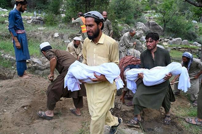 지난 1일 아프가니스탄 동부 쿠나르주의 한 피해 마을에서 주민들이 지진 희생자들을 운구하고 있는 모습. AFP 연합뉴스