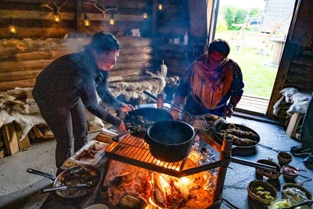 라플란드 사미족이 전통 천막 라부에서 음식을 준비하고 있다.