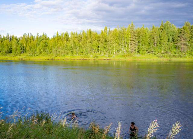 사우나를 즐긴 후 키틸라 오우나스강의 차가운 물속에서 수영을 즐기는 현지인의 모습.