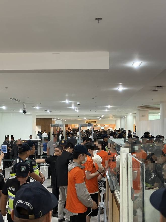 국내로 송환되는 피의자들이 필리핀 니노이 아키노 공항에서 출국심사를 받고 있다. / 경찰청 제공