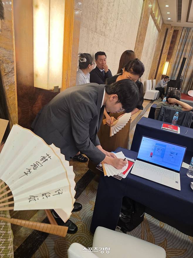 신진서 9단이 2일 중국 칭다오의 쉐라톤 칭다오 자오저우 호텔에서 열린 대회 사전 기자회견이 끝난 뒤 팬들에게 사인을 해주고 있다.  칭다오 | 윤은용 기자