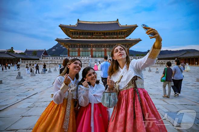 경복궁 야간 관람이 시작된 3일 오후 서울 종로구 경복궁을 찾은 외국인 관광객들이 근정전을 배경으로 셀카를 찍고 있다. 국 2025.9.3/뉴스1 ⓒ News1 김진환 기자