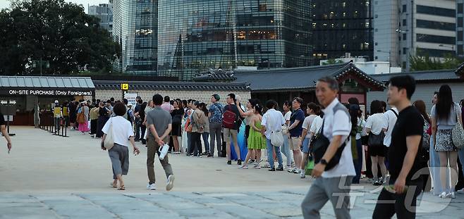 경복궁 야간 관람이 시작된 3일 오후 서울 종로구 경복궁을 찾은 외국인 관광객들이 현장판매줄에 서서 대기하고 있다.  2025.9.3/뉴스1 ⓒ News1 김진환 기자