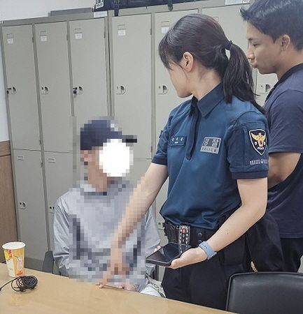 지난달 광안리해수욕장 일대에서 여성을 대상으로 불법촬영을 일삼은 혐의를 받고 있는 피의자 A씨(왼쪽)가 부산경찰청 기동순찰대의 조사를 받고 있다. 부산경찰청 제공