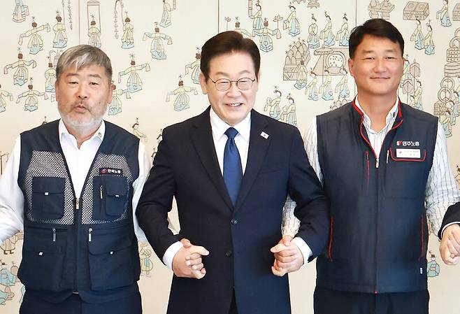 이재명 대통령이 4일 서울 용산 대통령실 청사에서 열린 양대노총 위원장과의 오찬 간담회에 참석해 김동명 한국노총 위원장(왼쪽), 양경수 민주노총 위원장과 기념촬영을 하며 손을 잡고 있다. 연합뉴스