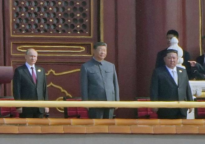 From left: Russian President Vladimir Putin, Chinese President Xi Jinping and North Korean leader Kim Jong-un stand on the rostrum of Tiananmen Gate in central Beijing to attend a military parade on Sept. 3 commemorating the 80th anniversary of Japan's surrender in World War II. [AP/YONHAP]