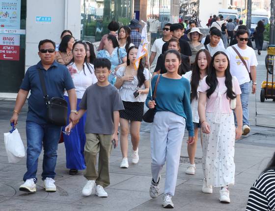 Foreign tourists visit Jagalchi Market in Busan on Aug. 21. [YONHAP]