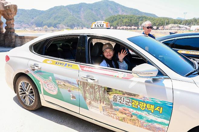 울진군 관광택시 이용객이 반갑게 인사하고 있다. 울진군 제공