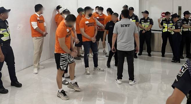 필리핀서 도피사범 49명 ‘최대 송환’ - 필리핀으로 도피한 보이스피싱 사범 등 49명이 한국으로 강제 송환됐다. 단일 국가 기준 최대 규모의 해외 도피사범 송환이다. 경찰청은 3일 오후 인천국제공항을 통해 피의자 49명(남성 43명, 여성 6명)을 강제 송환했다고 밝혔다. 사진은 필리핀 현지 공항서 강제 송환되는 한국인 도피사범들. 2025.9.3 경찰청 제공