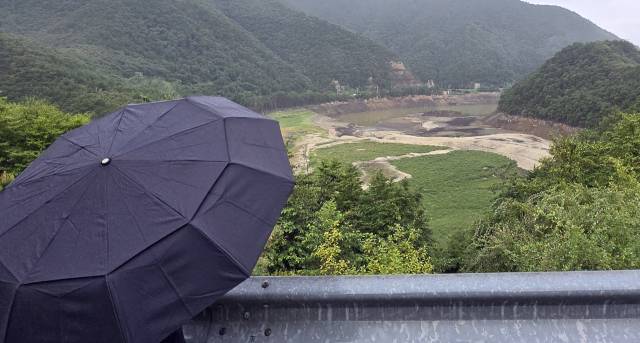 4일 강원 강릉시 주요 상수원인 오봉저수지 일원에 비가 내리고 있다. 한 강릉시민이 맨바닥을 드러낸 저수지를 바라보고 있다. 강릉=연합뉴스