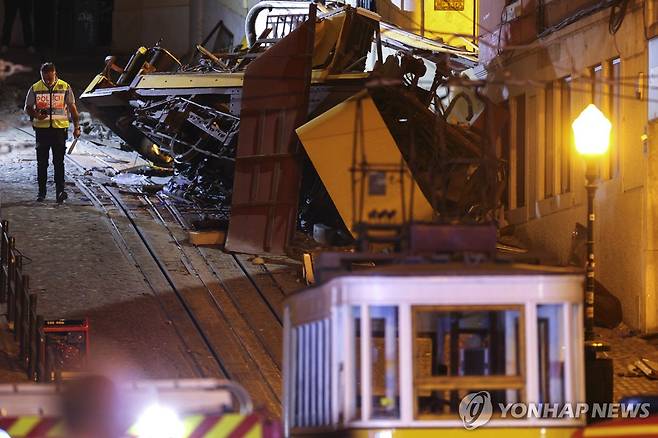 한 경찰관이 3일(현지시간) 사고가 발생한 포르투갈 리스본의 '글로리아' 노선 푸니쿨라 전차 옆에 서 있다. [EPA=연합뉴스]