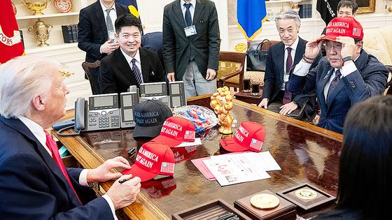 지난 4월 아카자와 료세이(오른쪽) 경제재생담당상이 미국 워싱턴DC 백악관에서 도널드 트럼프 대통령을 만나 '미국을 다시 위대하게'라는 의미를 담은 마가(MAGA) 모자를 착용해 보고 있다. 로이터=연합뉴스