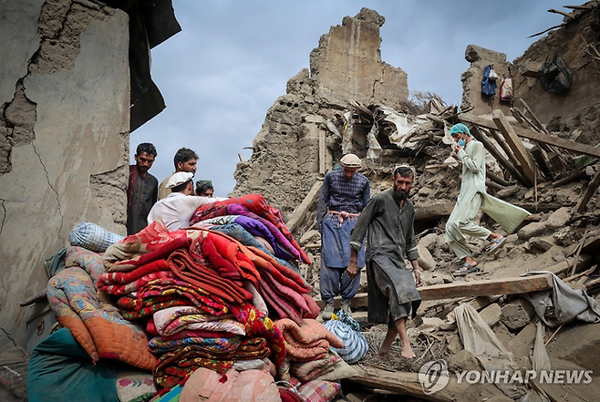 지난 2일(현지 시각) 아프가니스탄 동부 쿠나르주 마자르 다라 지역에서 지진으로 무너진 집 잔해를 주민들이 바라보고 있다. [로이터 = 연합뉴스]