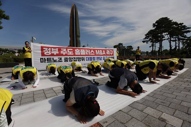 마트노조 홈플러스지부가 지난 3일 서울 용산구 대통령실 앞에서 이재명 대통령 면담과 정부 주도 M&A를 촉구하는 108배 행사를 하고 있다. [마트노조 제공]