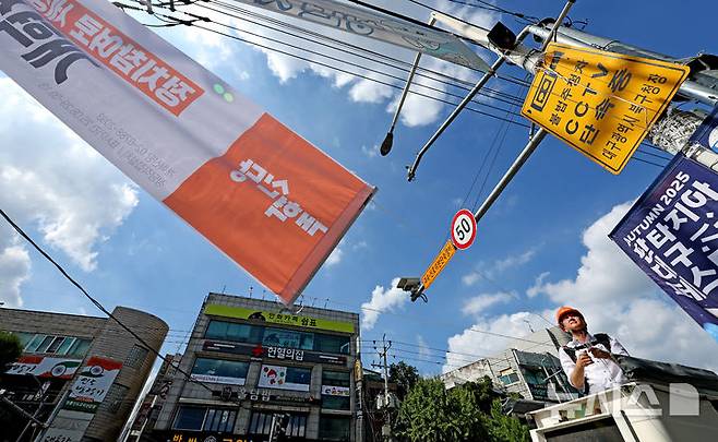 [대구=뉴시스] 이무열 기자 = 이준석 개혁신당 대표가 5일 대구 북구 경북대학교 북문 앞에서 정당 가입 독려 현수막을 직접 게첩하고 있다. 2025.09.05. lmy@newsis.com