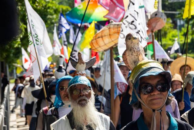 ▲5일 남태령 고개에 도착한 '새, 사람 행진단' 모습. 문정현 신부(가운데)가 새 모자를 쓰고 있다. ⓒ민주노총