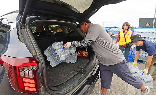 주민들이 5일 강원 강릉시 강남동 강남축구공원에서 배급하는 생수를 차에 싣고 있다. 강릉=연합뉴스