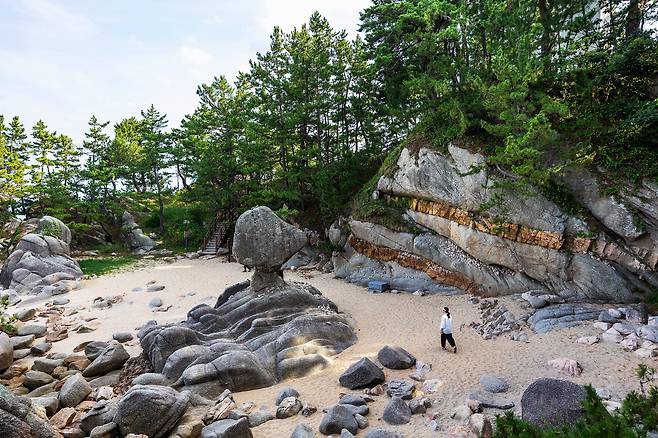 기이하게 생긴 '부채바위'(가운데)와 '서낭바위'(2시 방향)가 있는 고성 죽왕면 오호리 해변. 해변엔 시간과 자연이 조각한 기암괴석이 조각 박물관처럼 모여있다. / 양수열 영상미디어 기자
