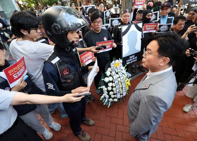 지난달 12일 양경수 민주노총 위원장 면담을 위해 서울 중구 전국민주노동조합총연맹(민주노총)을 방문한 김영훈 고용노동부 장관이 라이더유니온 관계자로부터 서한서를 받고 있다. 연합뉴스