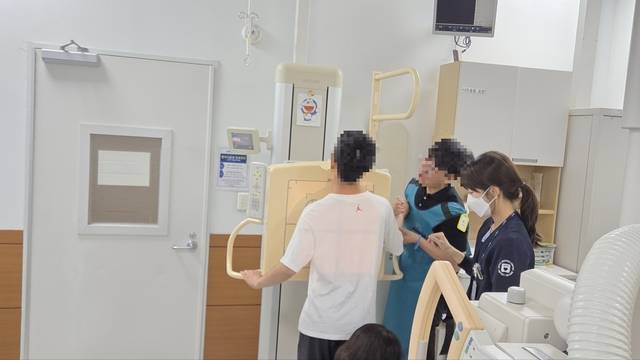 자폐스펙트럼 환자와 사회복지사가 4일 서울의료원 건강증진센터에서 엑스레이 촬영을 위한 준비를 하고 있다.