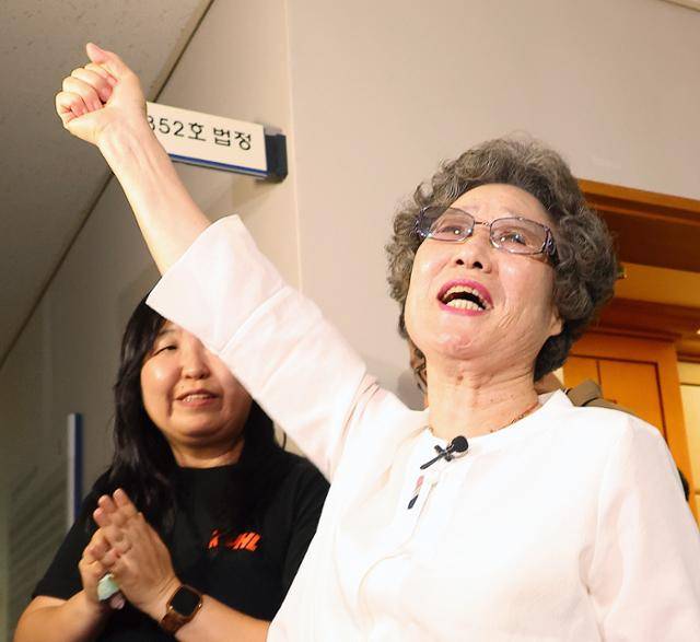 최말자씨가 7월 23일 부산지법에서 열린 재심 첫 공판을 마치고 법정을 나서며 손을 치켜 들며 "이겼습니다"를 외치고 있다. 연합뉴스
