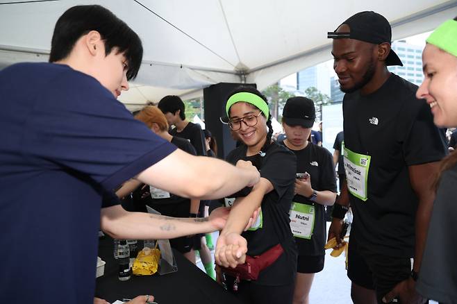 '런서울런 2025'의 KGM 부스에서 경기 시작 전 타투를 하고 있는 외국인 참가자들. 서병수 기자