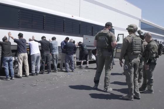 This image from video provided by U.S. Immigration and Customs Enforcement via Dvids shows manufacturing plant employees waiting to have their legs shackled at the Hyundai Motor Group’s electric vehicle plant in Ellabell, Georgia, on Sept. 4. [AP/YONHAP]